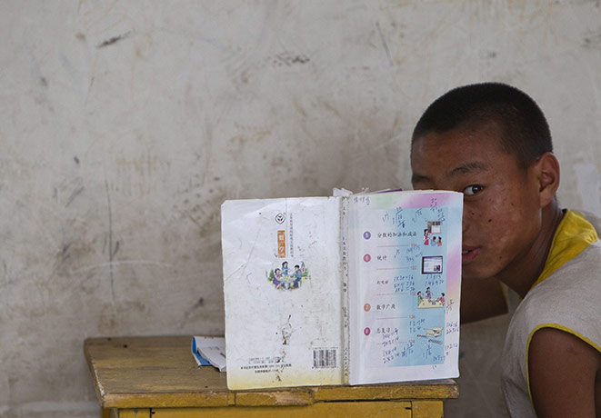 24 hours in pictures: Dengfeng, China: A Shaolin martial arts student looks up from a textbook