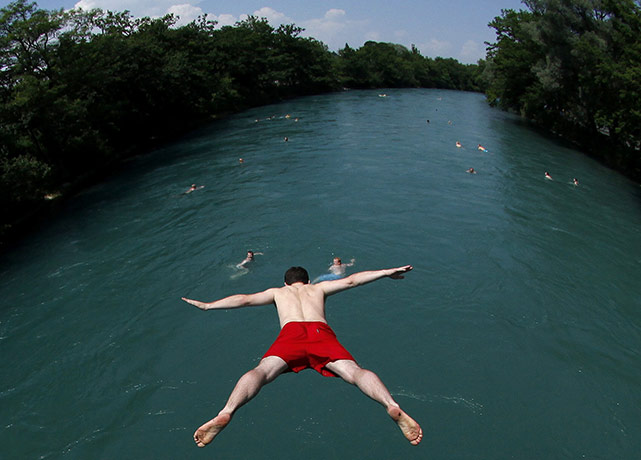 24 hours in pictures: Bern, Switzerland: A swimmer jumps into the river Aare
