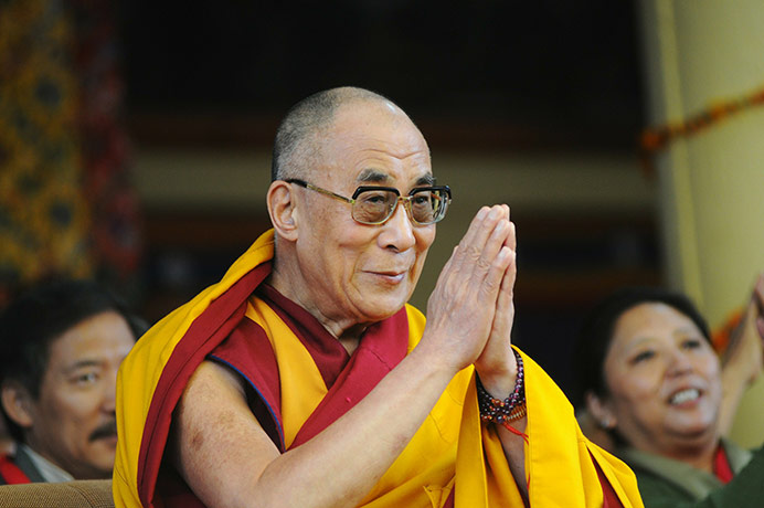 Moat: Dalai Lama gives a traditional greeting as he celebrates his 75th birthday