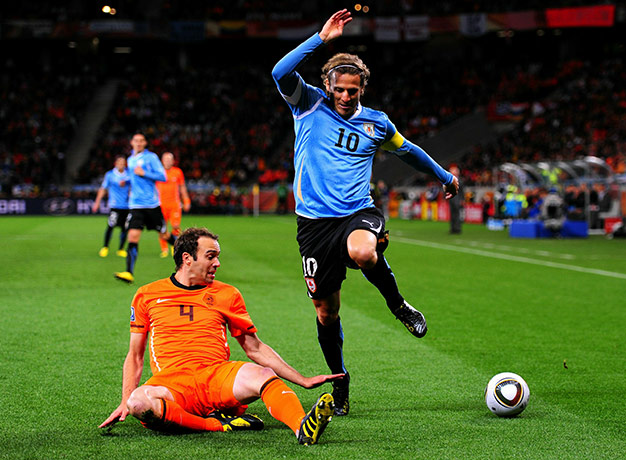 Holland : Joris Mathijsen knocks the ball away from Uruguay's Diego Forlan