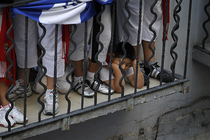 Pamplona bull running: A boy from El Salvador waits with his parents for the first run