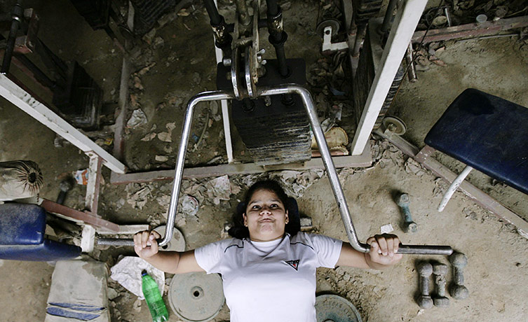 24 hours in pictures: New Delhi, India: A girl lifts weights before a wrestling practise session
