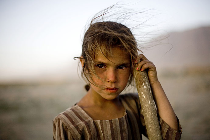 24 hours in pictures: Afghanistan: A girl who fixes potholes in a road between Kabul and Bagram
