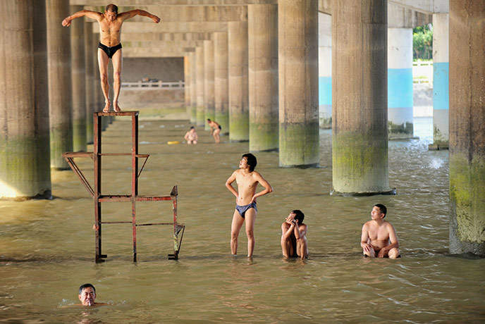 Heatwave: Quzhou, China: Residents swim under the Sunjiang Bridge to avoid the heat