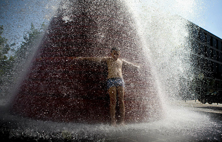 Heatwave: Lisbon, Portugal: A boy cools off in a fountain