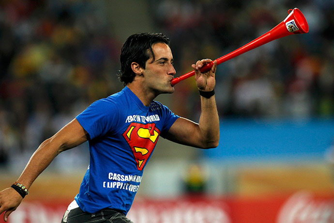 football: A man blows a vuvuzela