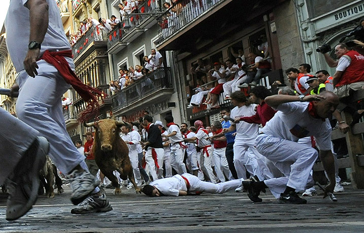 San Fermín fiesta: A participant falls while others run on the second bull run