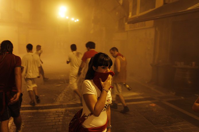 San Fermín fiesta: Revelers cover their faces when tear gas was released