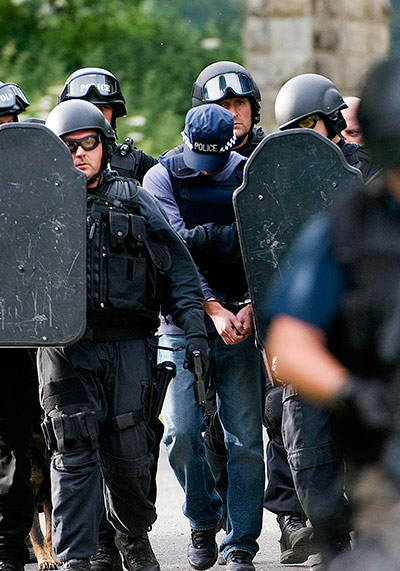 Raoul Moat update: Armed police escort a handcuffed unnamed man, Rothbury at Wagtail Farm