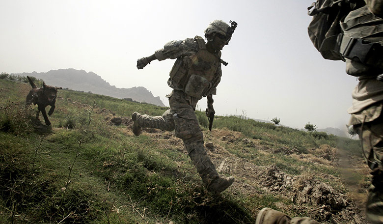 24 hours in pictures: A US Army doghandler and his dog Archie run for cover in Afghanistan