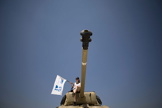 Gilad Shalit march: An Israeli girl sits on top of an old tank
