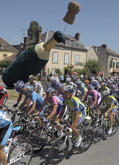 TDF stage 5: Riders snake past a champagne bottle made of flowers