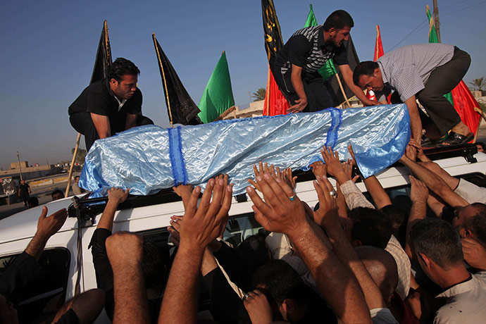 24 hours in pictures: Baghdad, Iraq: Mourners load the coffin of Ali Ahmed onto a bus