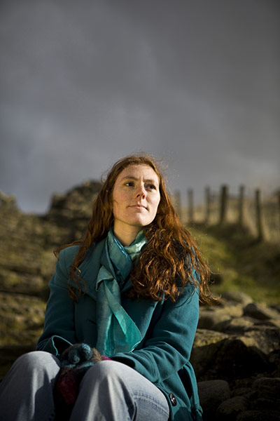 Fair Trade Town: A young woman with red hair sits in a rural setting