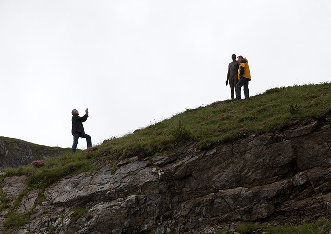Antony Gormley figures: A visitor has his photograph taken near one of the figures
