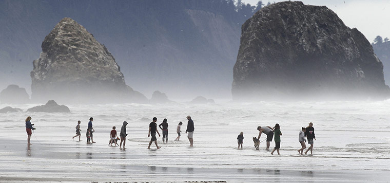 24 hours: Cannon Beach, Oregon, USA: Beachgoers play along the beach
