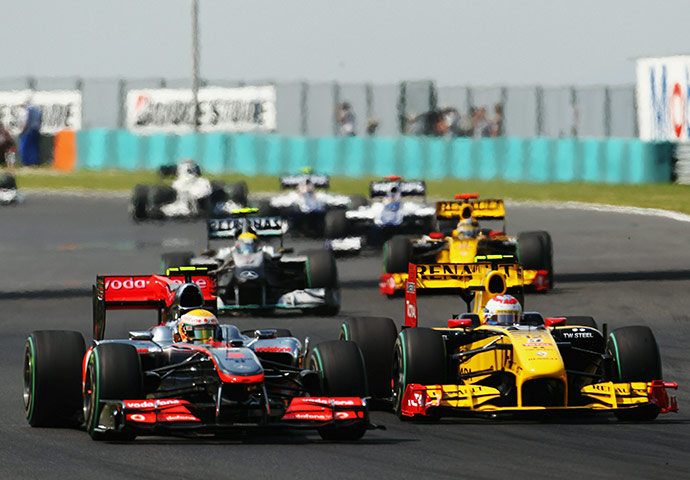 Hungarian grand prix: Lewis Hamilton drives beside Vitaly Petrov of Russia and Renault