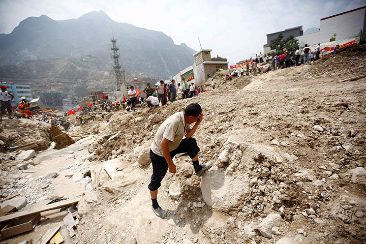 China floods update: A man mourns in the landslide-hit town in China.