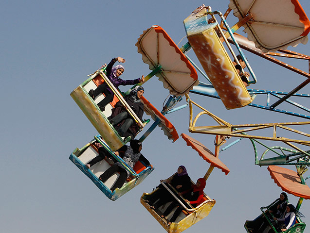 24 hours: A Palestinian raises her arms while on a ride at an amusement park in Jenin