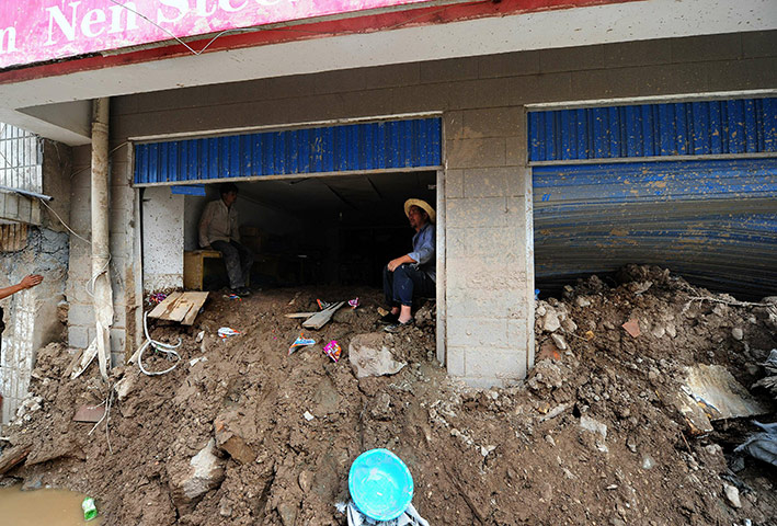 China update: Shopkeepers sit inside their mud covered store