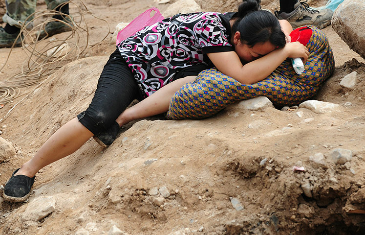 China update: A woman cries amid the rubble of landslide devastation
