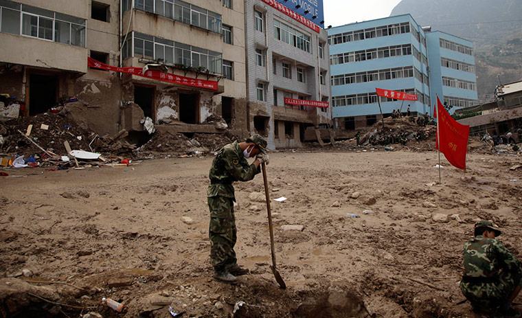 China update: A Chinese soldier rests on his shovel during an effort to dig out victims