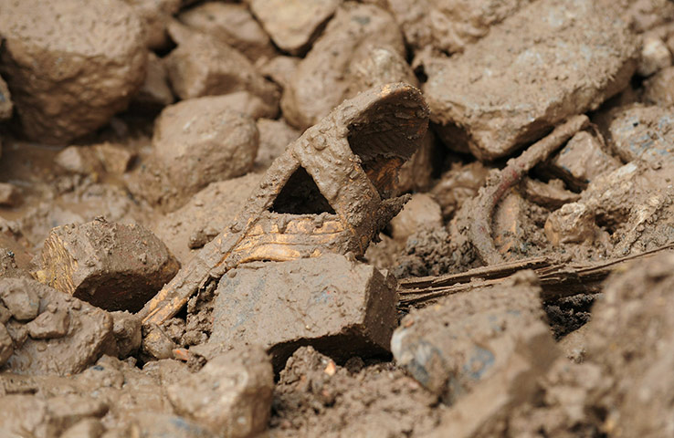 China update: A mud covered slipper remains amid the rubble of landslide
