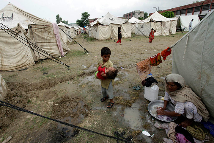 Pakistan Flood Disaster: A woman washes clothes  in a camp for flood displaced people in Pakistan 