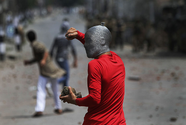 24 hours: Srinagar, India: A masked Kashmiri protester holds a brick and rocks