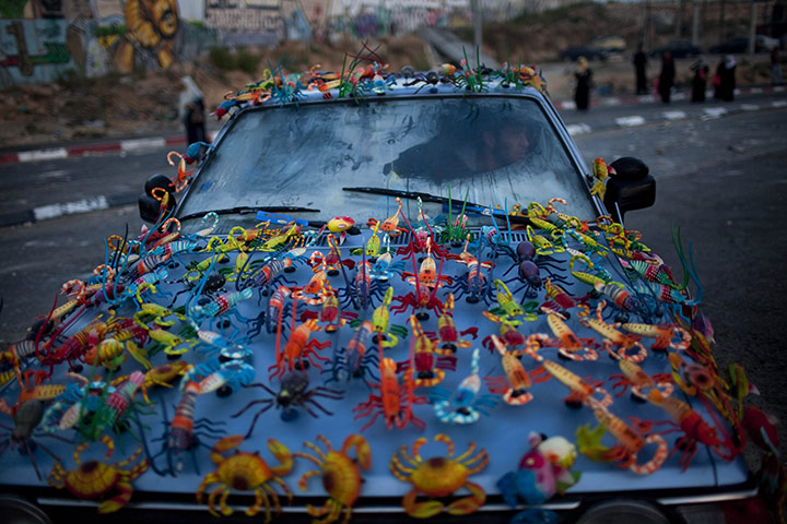 24 hours: West Bank: Magnets for sale are displayed on a Palestinian man's car