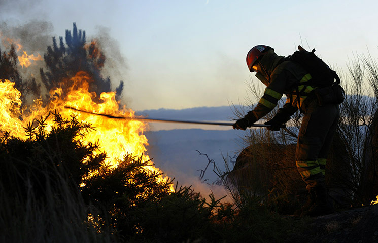 24 hours: Maside, Spain: A fireman fights with flames and raging fires
