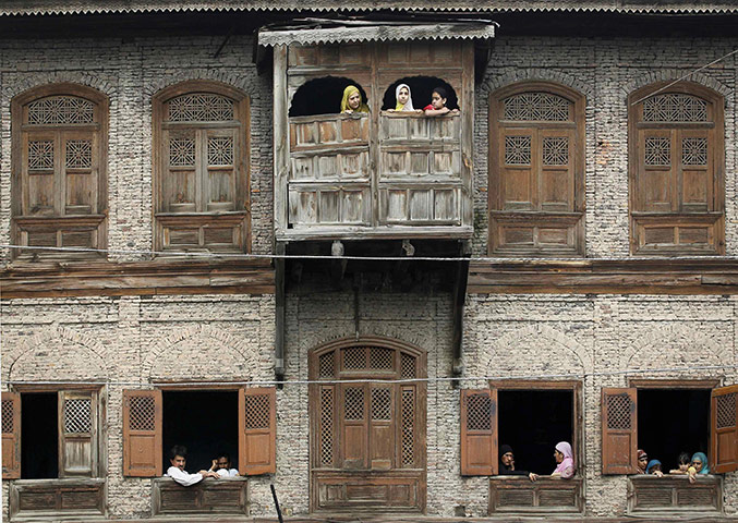 24 Hours in Pictures: People watch an anti-India protest march in Srinagar