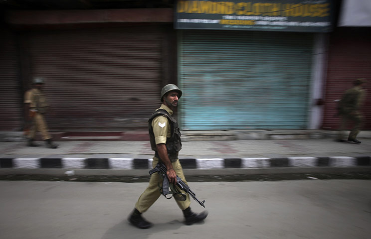 24 hours in pictures: Soldiers patrol a deserted street during curfew  in Kashmir