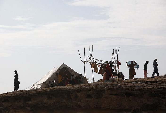 Pakistan flood survivors: A family takes refuge from flood waters on a mound in Sukkur