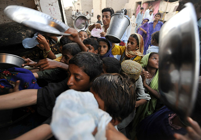 Pakistan flood survivors: Pakistani flood survivors struggle for charity food near a camp in Sukkur 