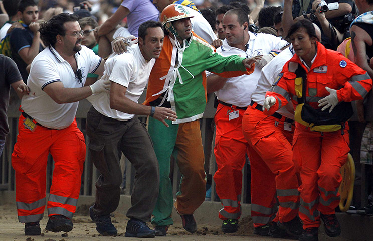 Palio race: Jockey of Selva parish Alberto Ricceri is helped after falling off 