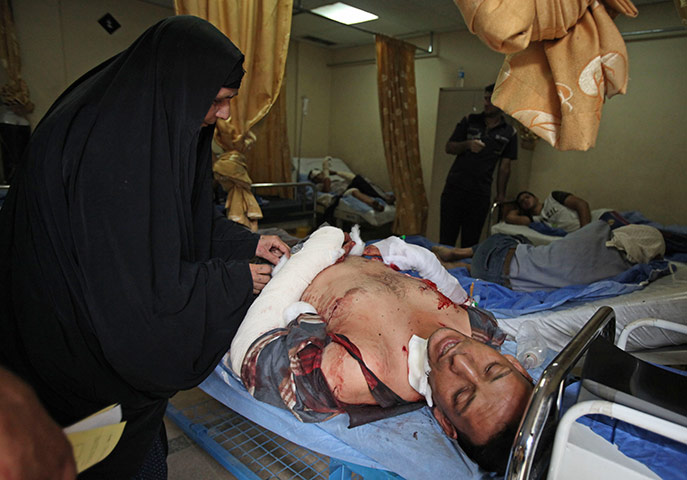 Baghdad bombing: An injured man is comforted by his mother at a hospital