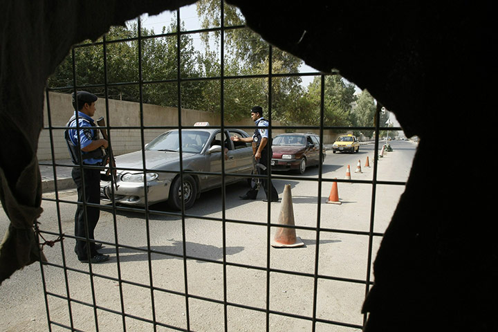 Baghdad bombing: Iraqi policemen stop cars for security checks in central Baghdad