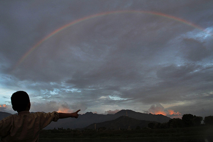 24 hours in pictures: Srinagar, India: A Kashmiri boy watches a rainbow above Babdemb lake 