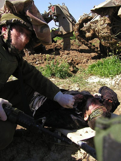 Israeli replace 2: members of the Israeli Defence Force posing with  injured Palestinians