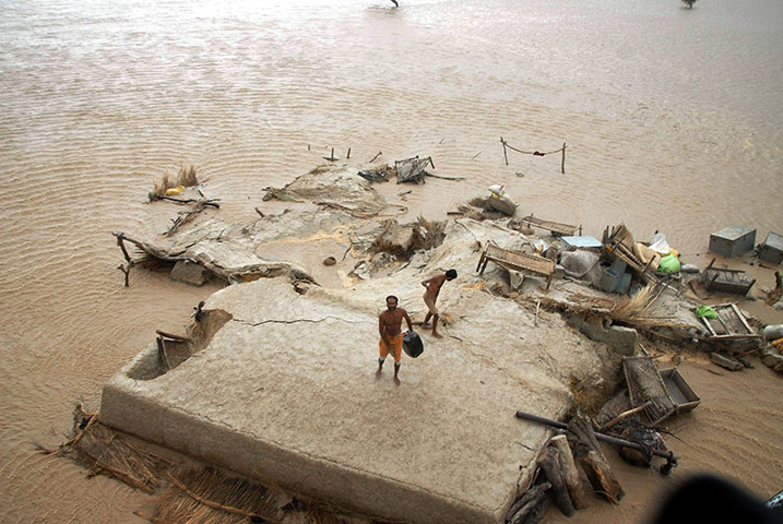 pakistan flooding: Villagers stand on a rooftop