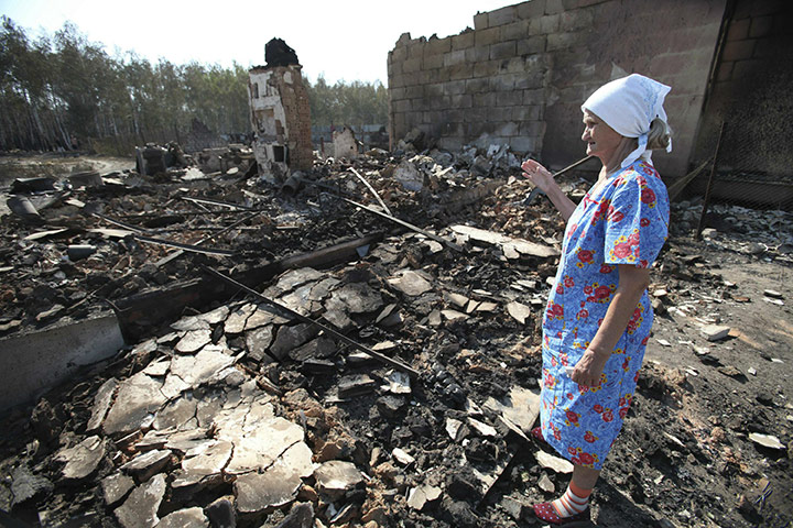 Forest fires in Russia: A Russian woman looks at the remains of her burnt out home in Voronezh 