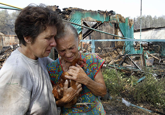 Forest fires in Russia: Women react while standing in front of the ruins of a house in Voronezh