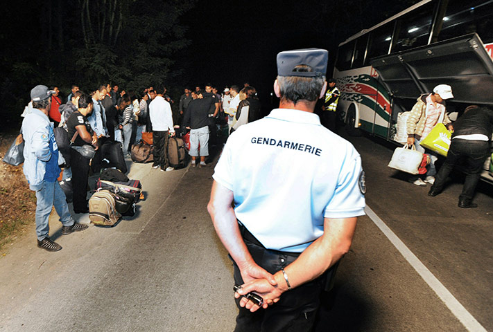 Roma deportation: French policemen stand guard next to a bus