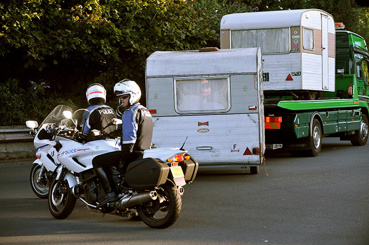 Roma deportation: A breakdown lorry carries caravans of people belonging to Roma community