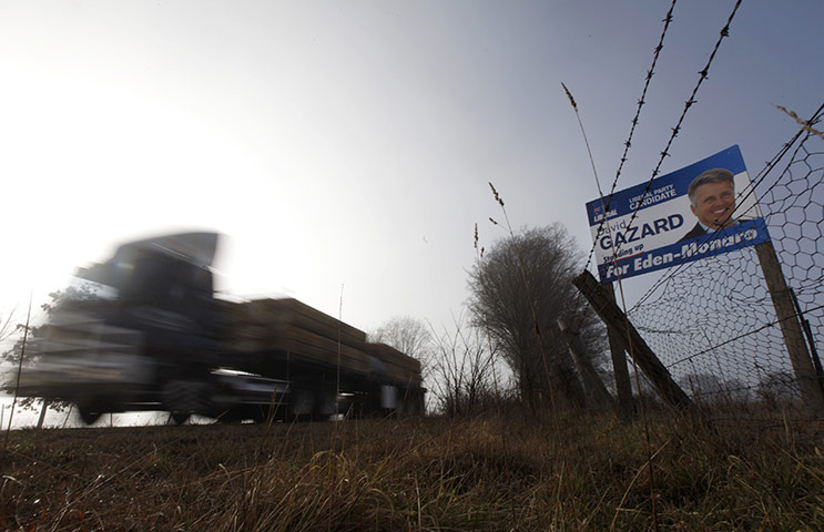 Australia Election: Truck carrying timber passes a sign, promoting a candidate
