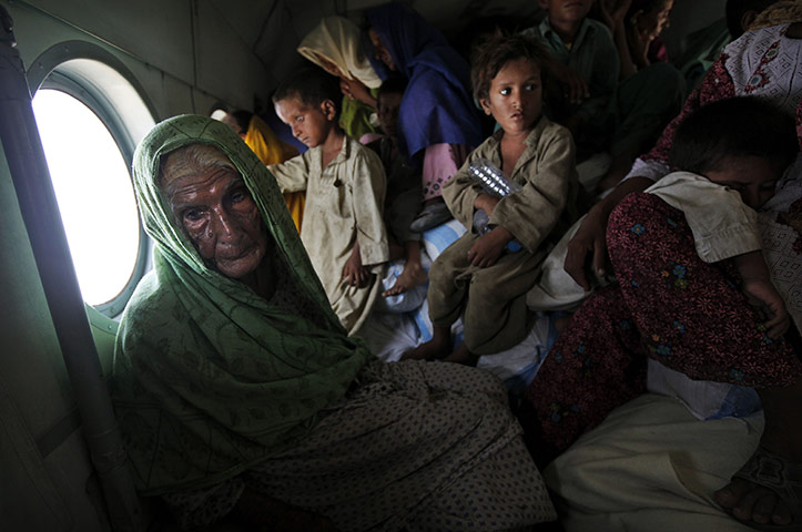 Pakistan Flood Update: Pakistanis displaced by flooding sit in a Pakistan Army helicopter 