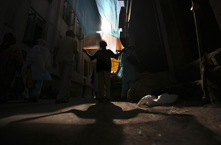 24 Hours: A young Kashmiri dries a dyed scarf outside a shrine in Indian Kashmir