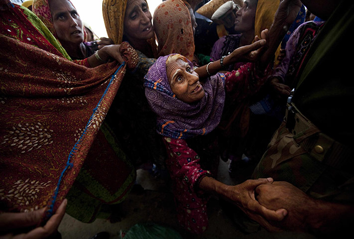 24 Hours: Pakistanis displaced by flooding wait for food at a camp in Jacobabad
