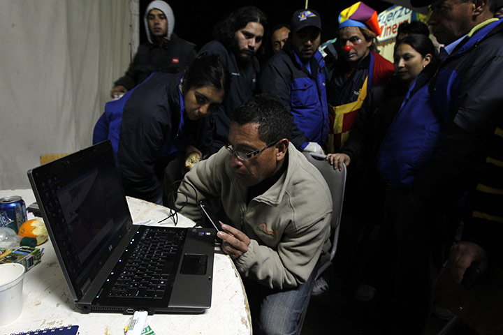 Chilean Miners Update: Volunteers watch a video of Chile's Mining Minister Golborne speaking
